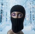 Black knit balaclava on a mannequin bust with a snowy background